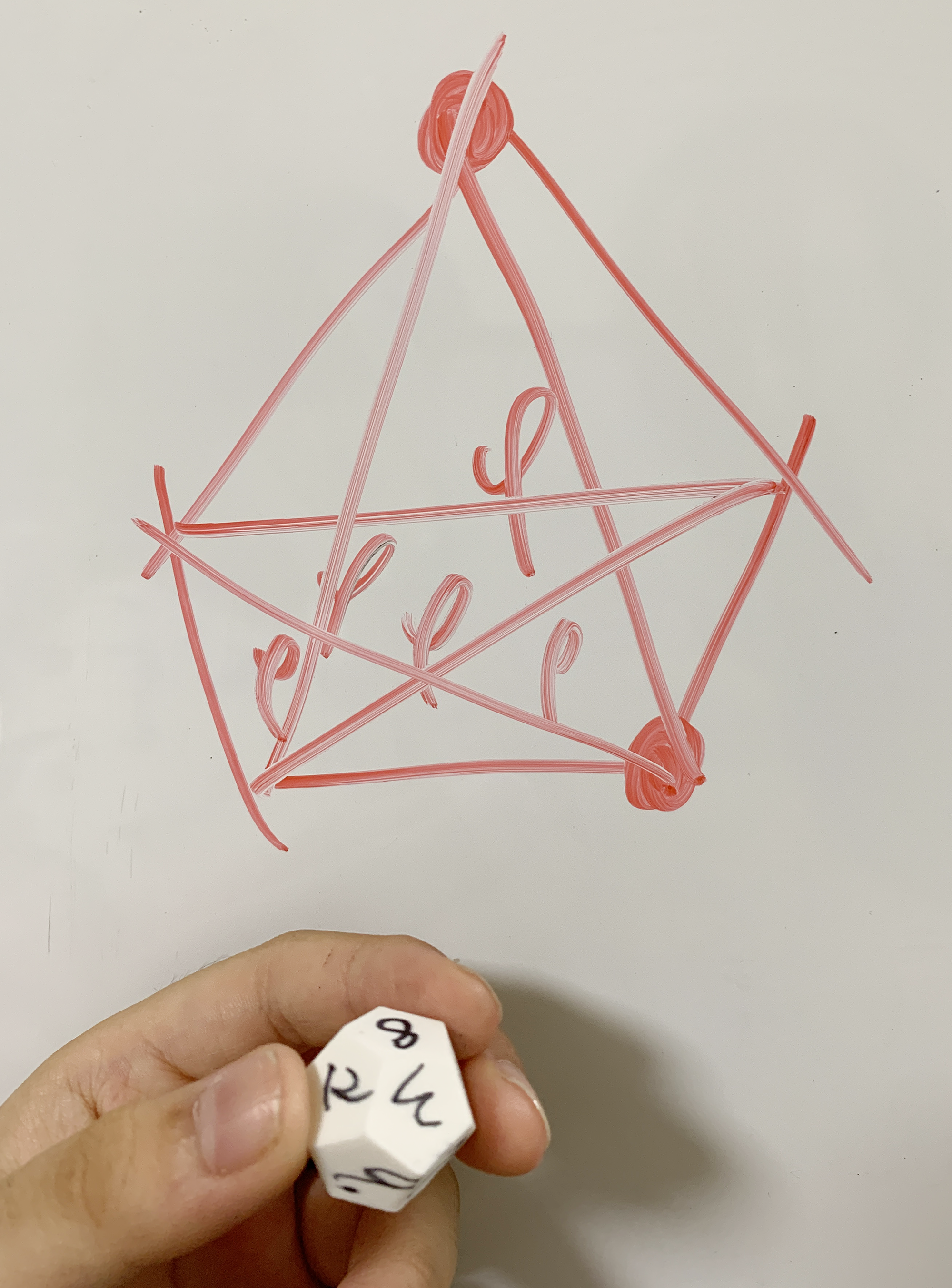 Whiteboard notes and a small physical model used to examine pentagonal distance relationships in a regular dodecahedron